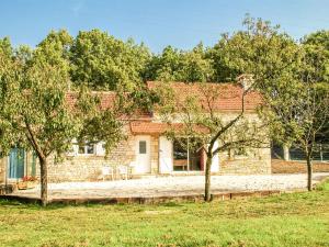 una casa de ladrillo con árboles delante de ella en Superb holiday home with pool en Cressensac