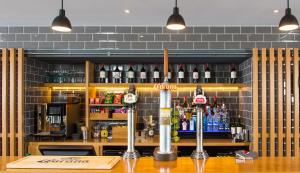 a bar with a counter with bottles of alcohol at Holiday Inn Express Edinburgh City West, an IHG Hotel in Edinburgh