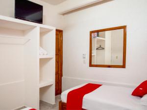 a white room with a bed and a mirror at Hotel Bello Caribe in Cozumel