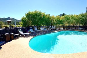 a large swimming pool with two chairs and an umbrella at Alpine Trail Ridge Inn in Estes Park