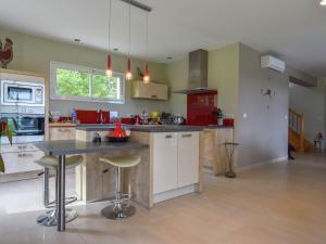 a large kitchen with a counter and stools in it at Delightful Holiday Home in Gindou with Private Swimming Pool in Gindou