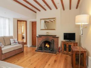 a living room with a fireplace and a tv at Wyke Lodge Cottage in Scarborough