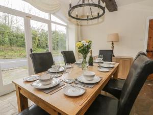 mesa de madera con sillas negras y comedor en Wyke Lodge Cottage, en Scarborough