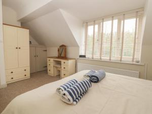 a bedroom with a white bed with blue and white towels at Wyke Lodge Cottage in Scarborough