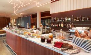 a buffet line with bread and pastries on display at 25hours Hotel Zürich West in Zürich
