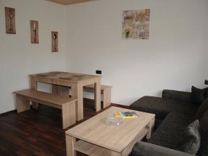 ein Wohnzimmer mit einem Sofa und einem Tisch in der Unterkunft Apartment in the Bavarian Forest with balcony in Drachselsried