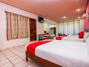チェトゥマルにあるOYO Hotel Nachancanのベッドルーム1室(ベッド2台付)、リビングルームが備わります。