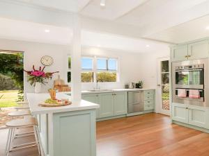 a kitchen with green cabinets and a white counter top at Whisky Creek in Berrima