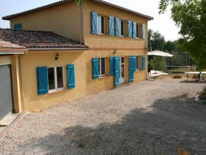 dom z niebieskimi okiennicami i żwirowym podjazdem w obiekcie Spacious villa in Piquecos with private pool w mieście Piquecos