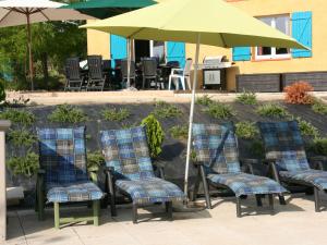 a group of chairs and an umbrella on a patio at Spacious villa in Piquecos with private pool in Piquecos