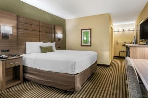 een hotelkamer met een groot bed en een televisie bij Best Western Downtown Stuart in Stuart