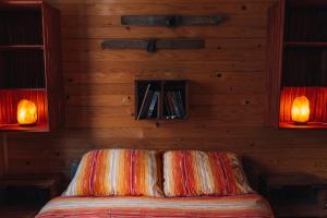 a bedroom with a bed with two lights on the wall at Apartman Pustolov - Stara planina in Crni Vrh
