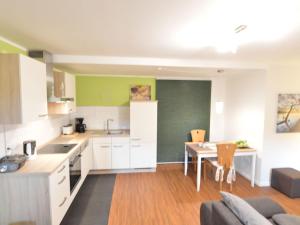 a kitchen and living room with a couch and a table at Spacious apartment in the Vulkaneifel in Ulmen