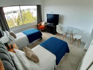 a hotel room with two beds and a television at Departamento en el centro de Bariloche NCC in San Carlos de Bariloche