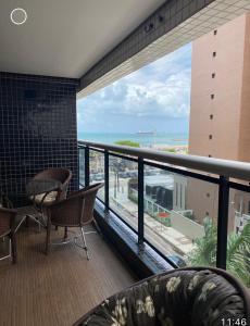 a balcony with chairs and a view of the ocean at LANDSCAPE - Apartamento Mobiliado na Beira Mar in Fortaleza