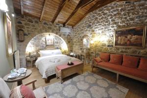 a bedroom with a bed in a stone wall at Armonia Hotel in Kefalari