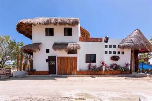 a house with a thatched roof on the beach at Mis Sueños Holbox in Holbox Island