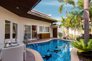 Village Austria Luxury Pool Villas في جنوب باتايا: مسبح في الحديقة الخلفية للفيلا