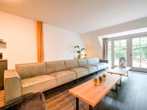 a living room with a couch and a table at Gorgeous Farmhouse with Sauna in Noardburgum in Noordbergum