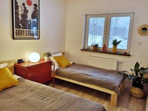 a room with two beds and a table and a window at Apartament Wrzosowa 25 in Kudowa-Zdrój