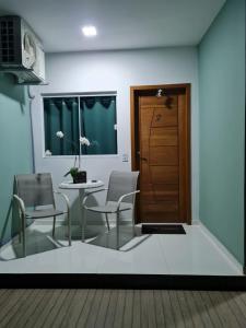 a room with a table and chairs and a door at Suites Golfo in Abraão