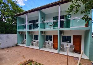 un bâtiment avec des tables et des chaises sur le balcon dans l'établissement Suites Golfo, à Abraão