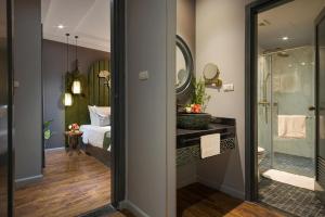 a bathroom with a shower and a bed and a mirror at Hanoi Center Silk Hotel & Travel in Hanoi