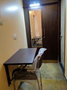 - une table en bois et une chaise dans la chambre dans l'établissement Chandru De Green, à Chennai