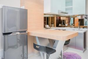 eine Küche mit einer Holztheke und einem Kühlschrank in der Unterkunft Great Choice 1BR at Brooklyn Alam Sutera Apartment By Travelio in Dongkal Dua