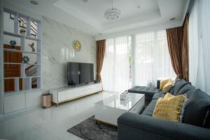 a living room with a couch and a tv at KW pool villa pattaya in Pattaya Central