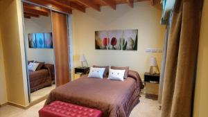 a bedroom with a bed and a couch and a mirror at El Buen Descanso in Río Gallegos