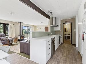 une cuisine et un salon avec un canapé et une table dans l'établissement Lake House and Studio - Lake Rotoiti Holiday Home, à Okere Falls