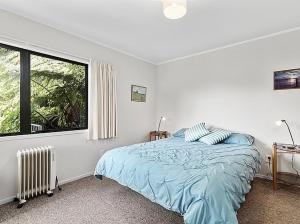 une chambre avec un lit et une grande fenêtre dans l'établissement Lake House and Studio - Lake Rotoiti Holiday Home, à Okere Falls