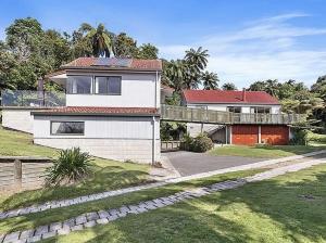 une grande maison blanche avec une passerelle devant elle dans l'établissement Lake House and Studio - Lake Rotoiti Holiday Home, à Okere Falls
