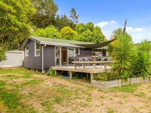 ein kleines Haus mit einer Veranda und einer Terrasse in der Unterkunft Fantail Cottage - Lake Rotoiti Holiday Home in Rotoiti