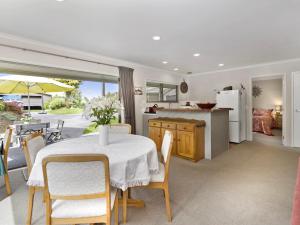 a kitchen and dining room with a table and chairs at Te Miro Cottage - Lake Tarawera Cottage in Lake Tarawera