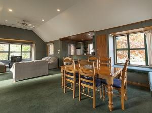 a living room with a wooden table and chairs at Tranquil Tipperary - Arrowtown Holiday Home in Arrowtown