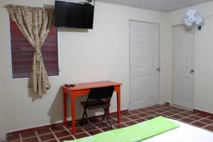 Zimmer mit einem Schreibtisch, einem Stuhl und einem Fenster in der Unterkunft Casa Central completa in Santa Ana