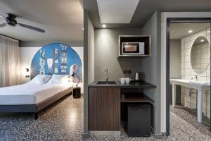 - une chambre avec un lit, un lavabo et un miroir dans l'établissement DINA MORGABINE SAINT DENIS, à Saint-Denis