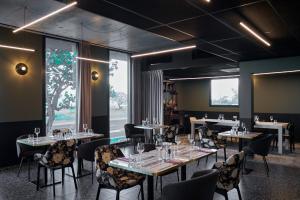 a dining room with tables and chairs and windows at DINA MORGABINE SAINT DENIS in Saint-Denis