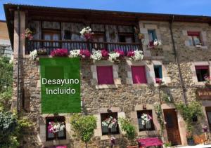 un edificio con flores en sus balcones en Posada Rural Bistruey, en Potes
