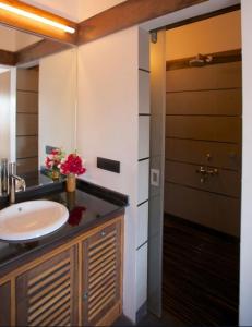 a bathroom with a sink and a mirror and a door at Dunhill Beach Resort in Agonda
