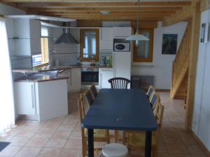 cocina y comedor con mesa azul y sillas en Spacious chalet near the ski area, en Saint-Jean-dʼAulps