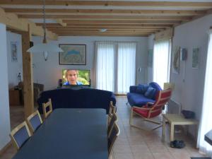 a room with a table and a woman on a television at Spacious chalet near the ski area in Saint-Jean-d'Aulps