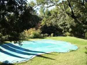 een blauwe vijver in het midden van een veld bij Modern villa with private pool in Roquebrun in Crillon-le-Brave