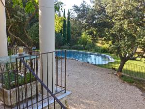 een hek met een zwembad in een tuin bij Modern villa with private pool in Roquebrun in Crillon-le-Brave