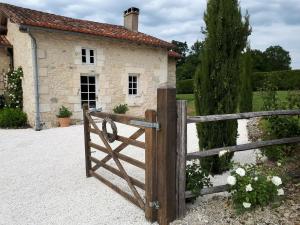 a wooden gate in front of a stone house at Holiday home with pool in Verteillac in Verteillac