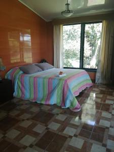 a bedroom with a large bed with a colorful blanket at Suite y Loft Casa Toría in San Isidro
