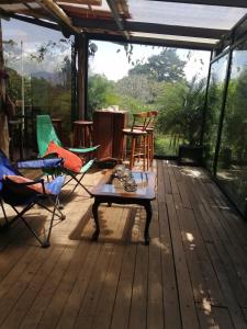 eine Holzterrasse mit Stühlen und einem Tisch darauf in der Unterkunft Suite y Loft Casa Toría in San Isidro