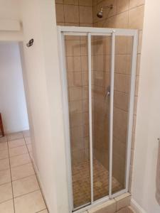 y baño con ducha y puerta de cristal. en Birds Holiday Accommodation 1, en Ciudad del Cabo